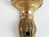a gold candle holder on a white wall next to a white wall