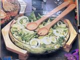 a picture of a box of salad with wooden spoons in it