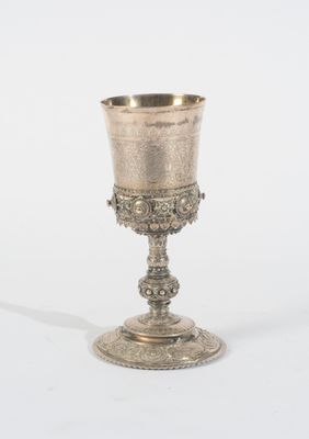 un gobelet en argent posé sur une surface blanche