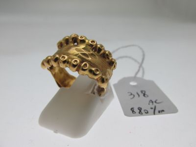 an image of a gold ring on a white surface with a price tag