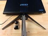 un ordinateur portable posé sur un trépied, sur une table