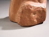 a stone sculpture of a face on a white surface