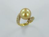 une bague en or sertie d'une perle et de diamants, sur fond blanc