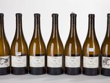 six bottles of wine are lined up in a row on a table