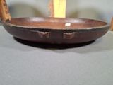 a wooden bowl sitting on a table next to a wooden chair