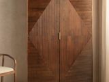 Le meuble en bois se trouve à côté d'une chaise blanche dans une pièce