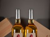 two bottles of wine sitting next to each other on a table