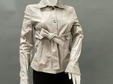 a mannequin wearing a beige leather jacket and black pants