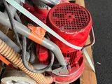 a small red machine that is sitting on a pallet