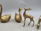 trois figurines en laiton représentant des animaux et un oiseau sur fond blanc