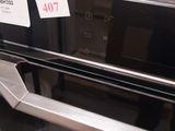 an image of a black and silver oven with a price tag on it