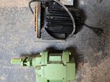 a green machine that is on the ground next to a hose