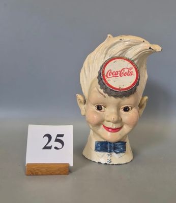a small statue of a boy with a bottle cap on his head