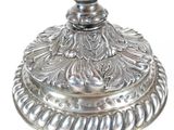 a silver candle holder with a flower design on it