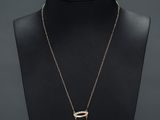un collier avec une pièce et une chaîne sur un mannequin