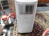 a small air conditioner sitting on a rug on the floor