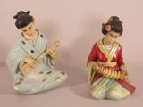 pair of asian figurines of a woman and a man playing instruments