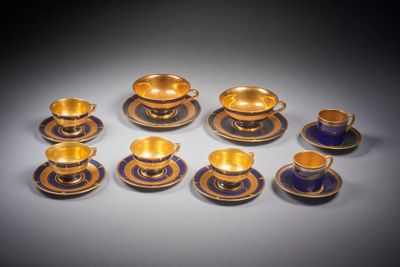 six tasses et soucoupes aux bords dorés sur fond gris