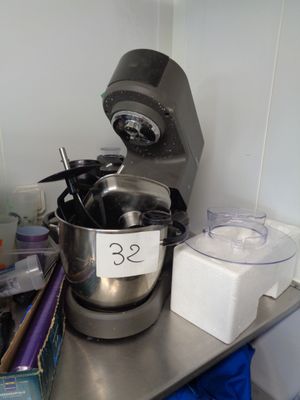 un mixeur argenté posé sur un plan de travail en métal dans une cuisine