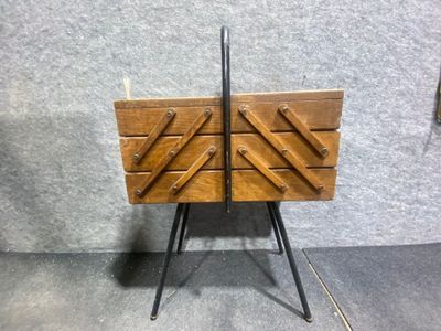 une vieille commode en bois avec des poignées en métal, posée sur un socle