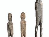 three wooden statues of men standing next to each other on a white surface