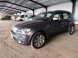 a picture of a grey bmw suv parked in a garage