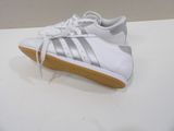 white and silver adidas sneakers on a white surface