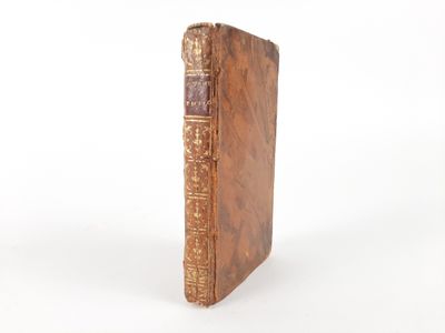 an old book sitting on top of a white table next to a white wall
