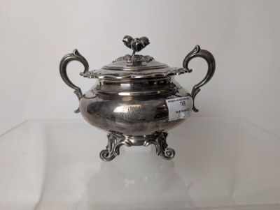 a silver plate with a bird on it on a glass table