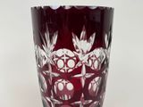 a red glass with a pattern on it on a table