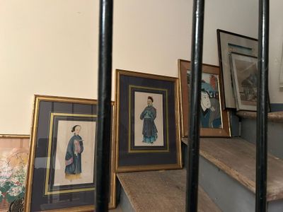 il y a de nombreux tableaux encadrés dans l'escalier de cette pièce