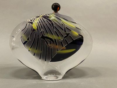 a glass vase with a black and yellow design on it