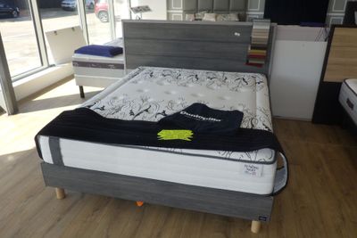 un lit sur lequel est posé un matelas dans une pièce