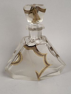 une bouteille en verre transparent ornée d'un motif doré