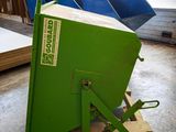 a green dumpster sitting in the middle of a warehouse