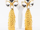 pair of gold tone earrings with black and white stones
