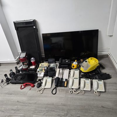 beaucoup d'appareils électroniques posés par terre devant un téléviseur