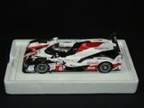 une maquette de voiture de course posée sur un plateau blanc