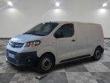 la camionnette blanche est garée dans une grande pièce au sol en damier