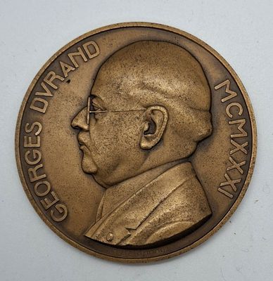 an image of a bronze medal with a man ' s face on it