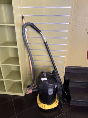 un aspirateur posé par terre à côté d'une bibliothèque