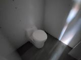 a white toilet sitting in a small room with a window