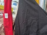 a black apron and a red apron hanging on a rack