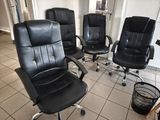 quatre chaises de bureau noires dans une pièce au sol carrelé