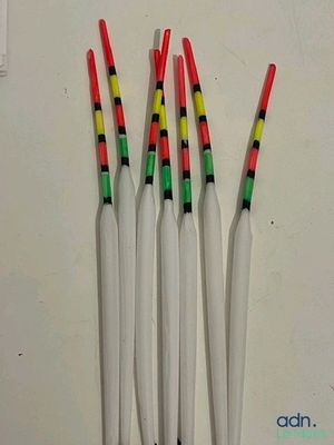 quatre battes de baseball en plastique sont alignées contre un mur blanc