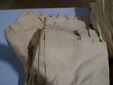 une pile de pantalons beiges posée sur une table bleue