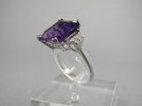une bague en améthorate et diamant exposée sur un socle transparent
