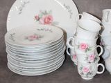 a lot of plates and cups that are sitting on a table