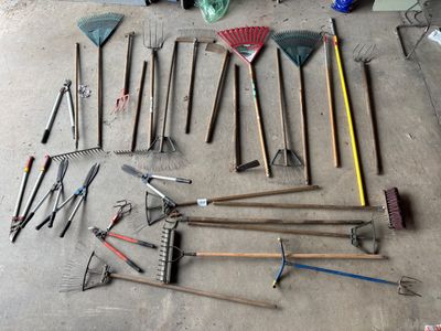 de nombreux outils de jardinage de toutes sortes, disposés par terre