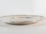 a silver plate with a handle on a white surface